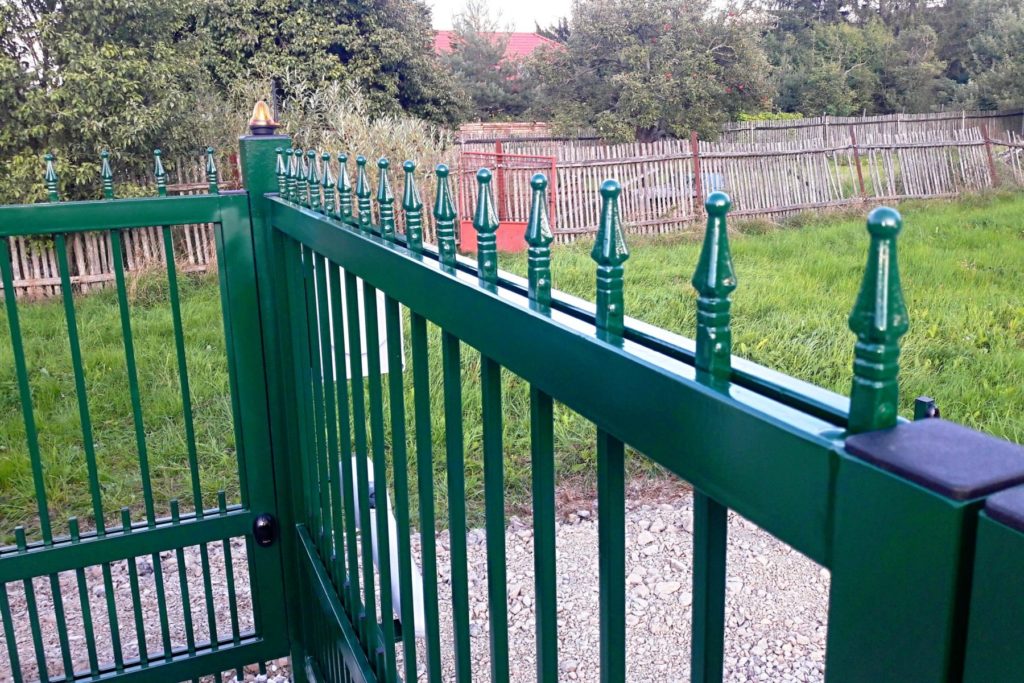 Detail křídlové brány s integrovanou brankou, výplň brány ukončená kovanými hroty